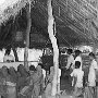 A priest from parish headquarters saying Mass in the village's open prayer hut.