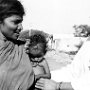 A sister inspecting a baby when visiting an pit;ying village.<br />