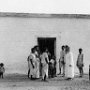 Fr Boon MHM standing with some parishioners at the entrance of the small chapel in their village.