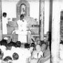 A priest celebrates Mass in a small village chapel.